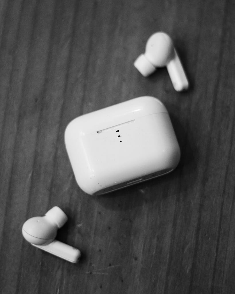 Close-up of SoundPEATS Free2 Classic wireless earbuds and charging case on wood surface