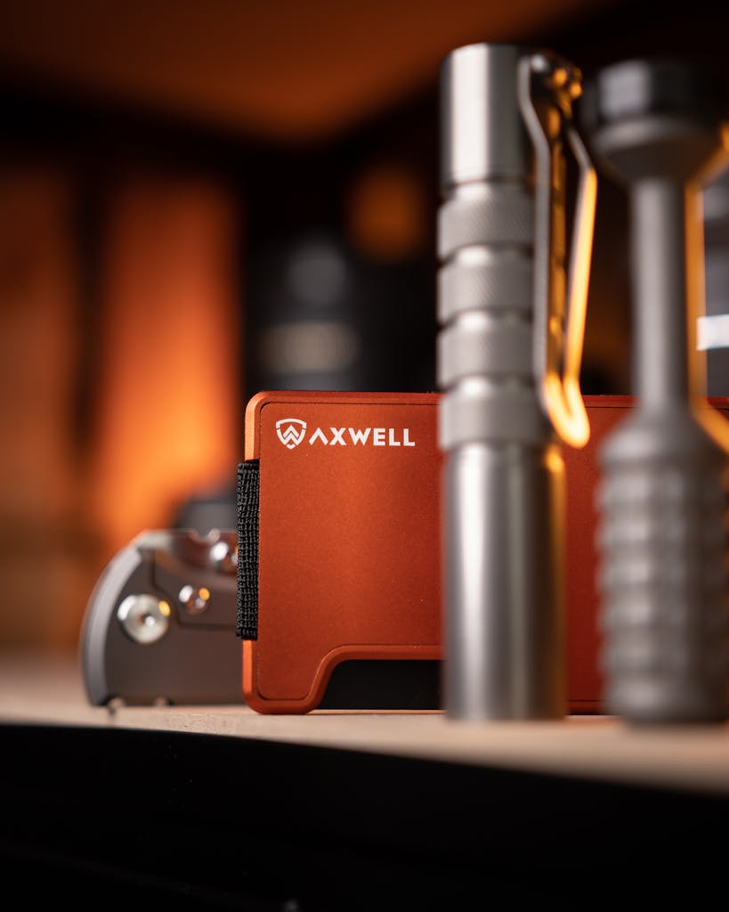 Detailed shot of an Axwell wallet with a flashlight and multitool on a wooden surface.