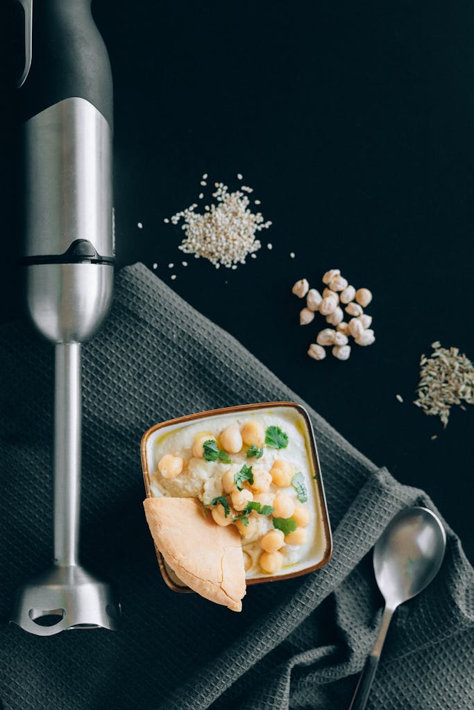 Hamilton Beach 2-speed hand blender with whisk and chopping bowl on a wooden surface