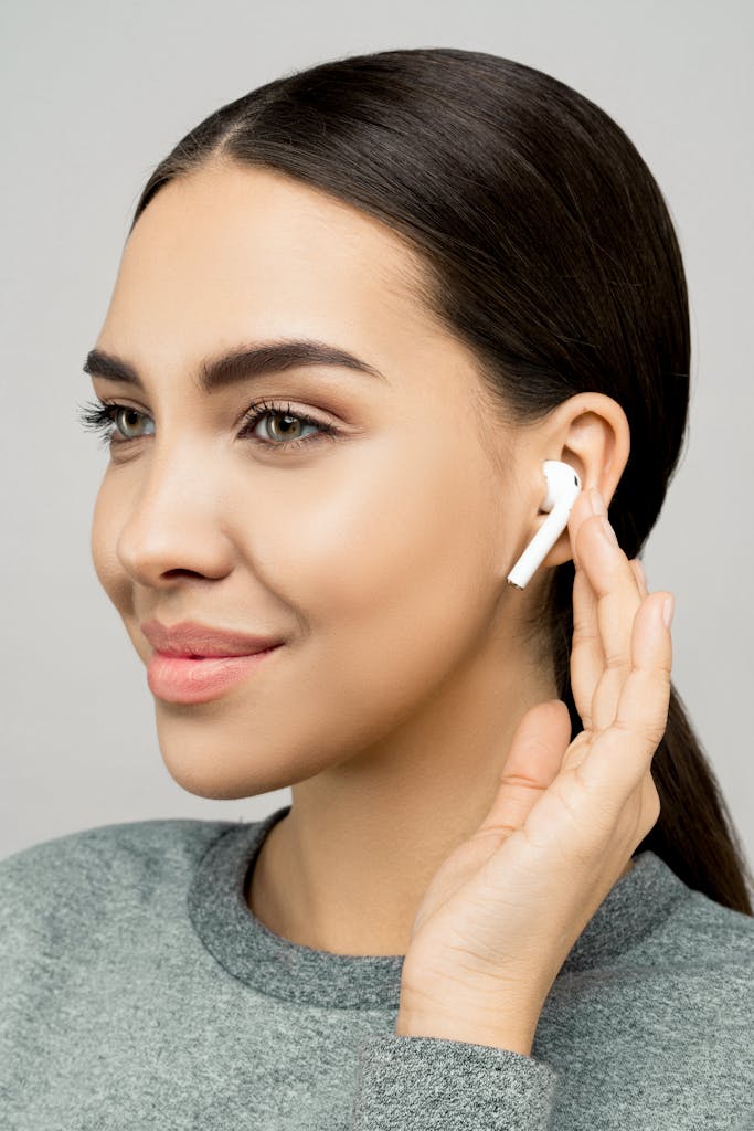 Portrait of a woman wearing Skullcandy Dime 2 True wireless earphones, smiling softly.